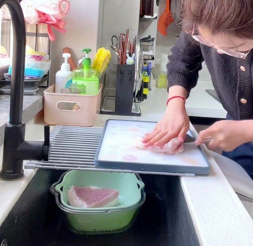 도마 위에서 중식도를 사용하여 돼지 등심을 1cm 두께로 썰고 있는 모습