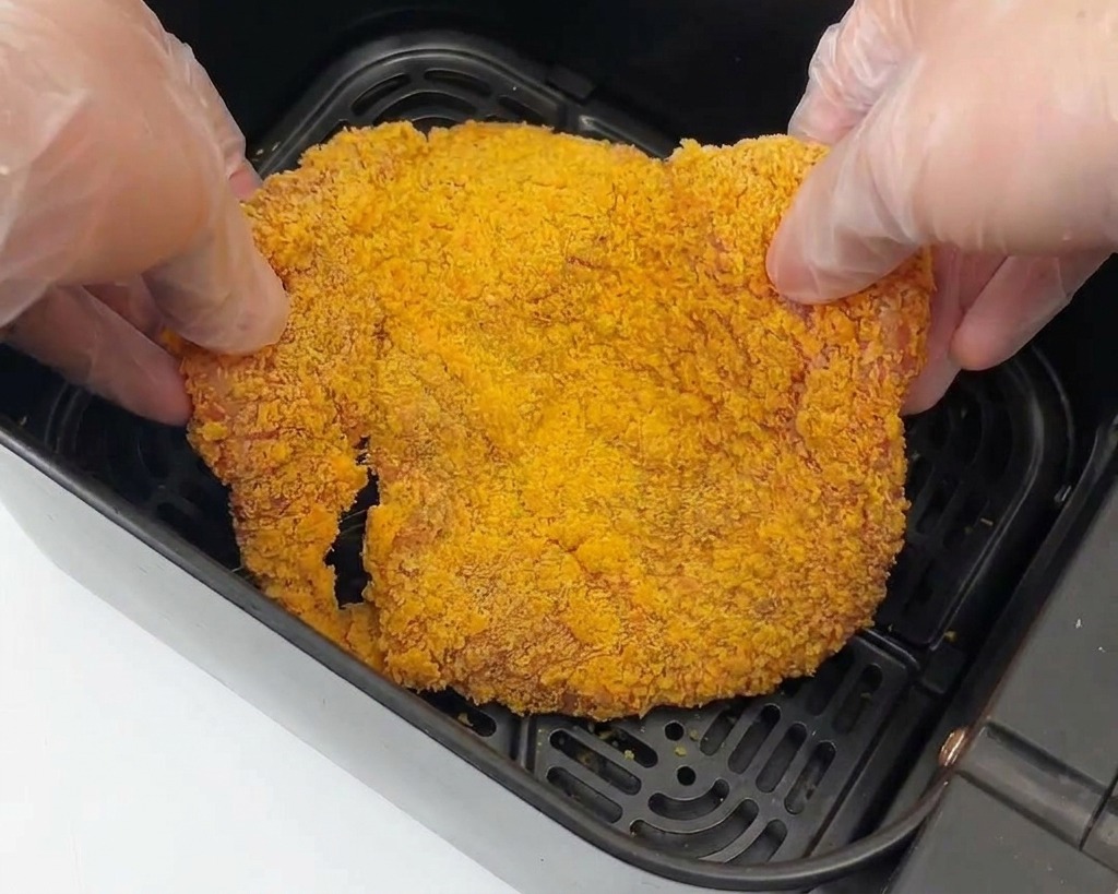 에어프라이어 바스켓 안에 치킨 가츠를 겹치지 않게 배치하는 모습.