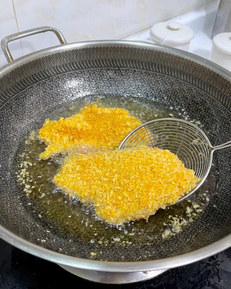 황금빛으로 잘 익은 치킨까스를 뒤집는 모습
