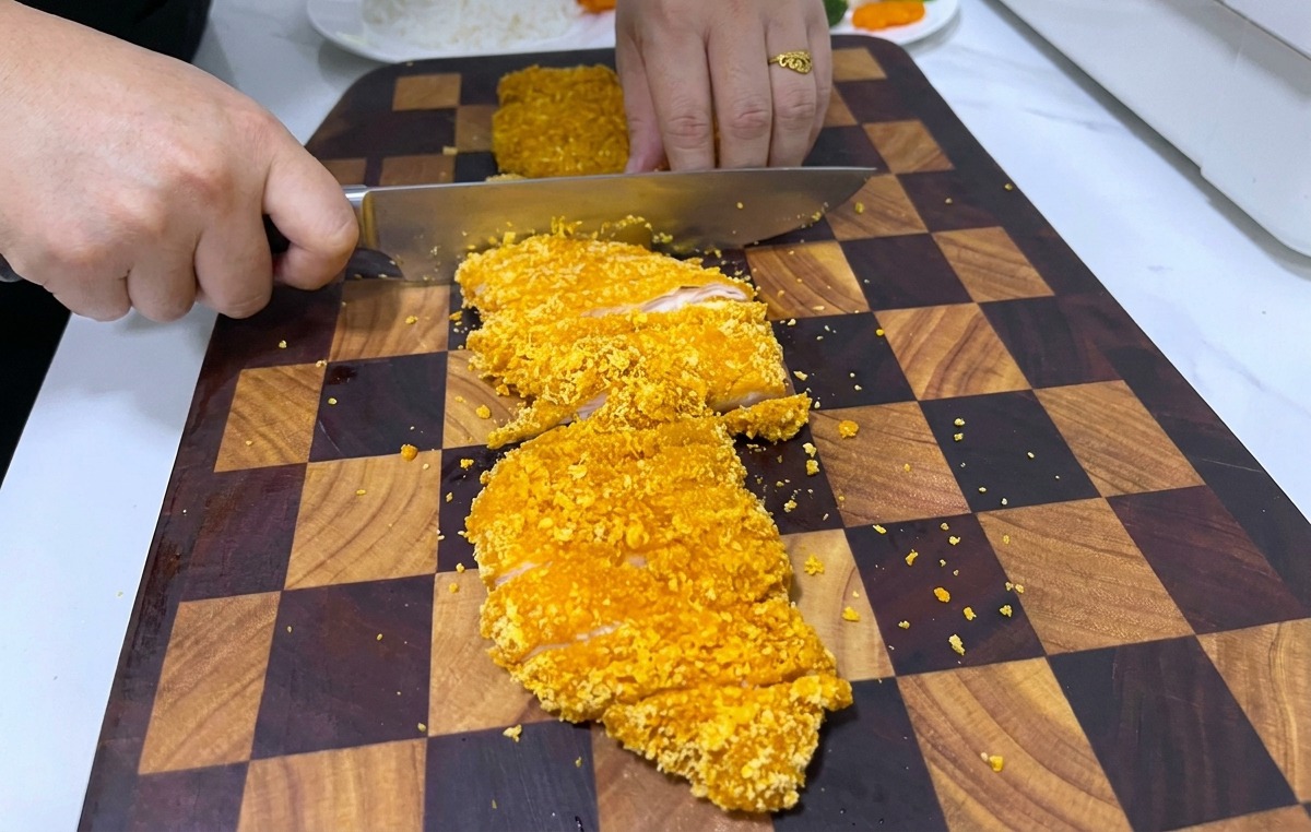 도마 위에서 바삭한 치킨까스를 먹기 좋게 써는 장면