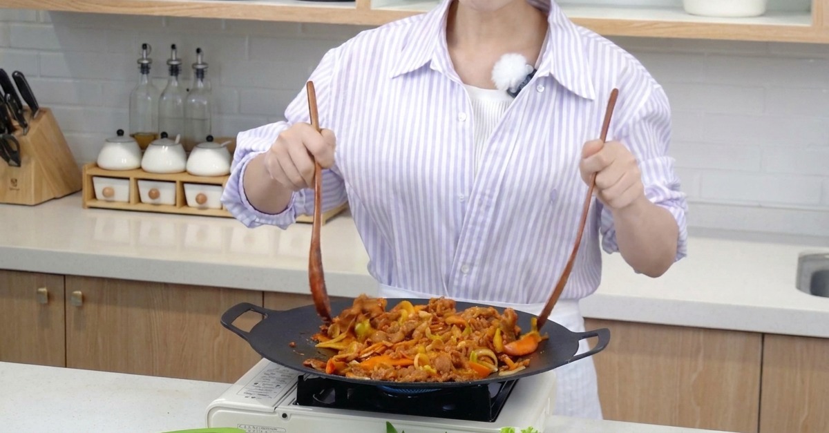 두 개의 주걱으로 고기와 채소를 힘차게 섞으며 볶는 모습