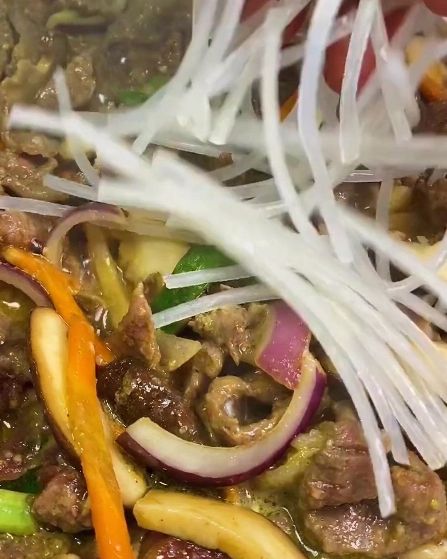 보글보글 끓는 소불고기 팬에 불려둔 투명한 당면 뭉치를 넣는 모습