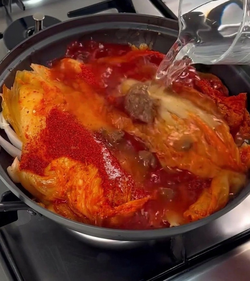양념이 된 재료들이 담긴 냄비에 깨끗한 물을 붓는 모습.