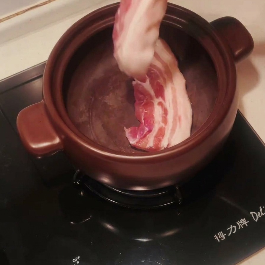 예열된 뚝배기에 통삼겹살을 넣고 굽는 모습