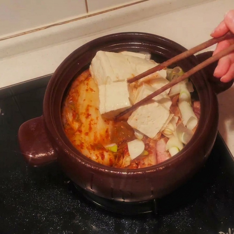 도톰하게 썬 두부를 찌개 재료 위에 가지런히 놓는 모습