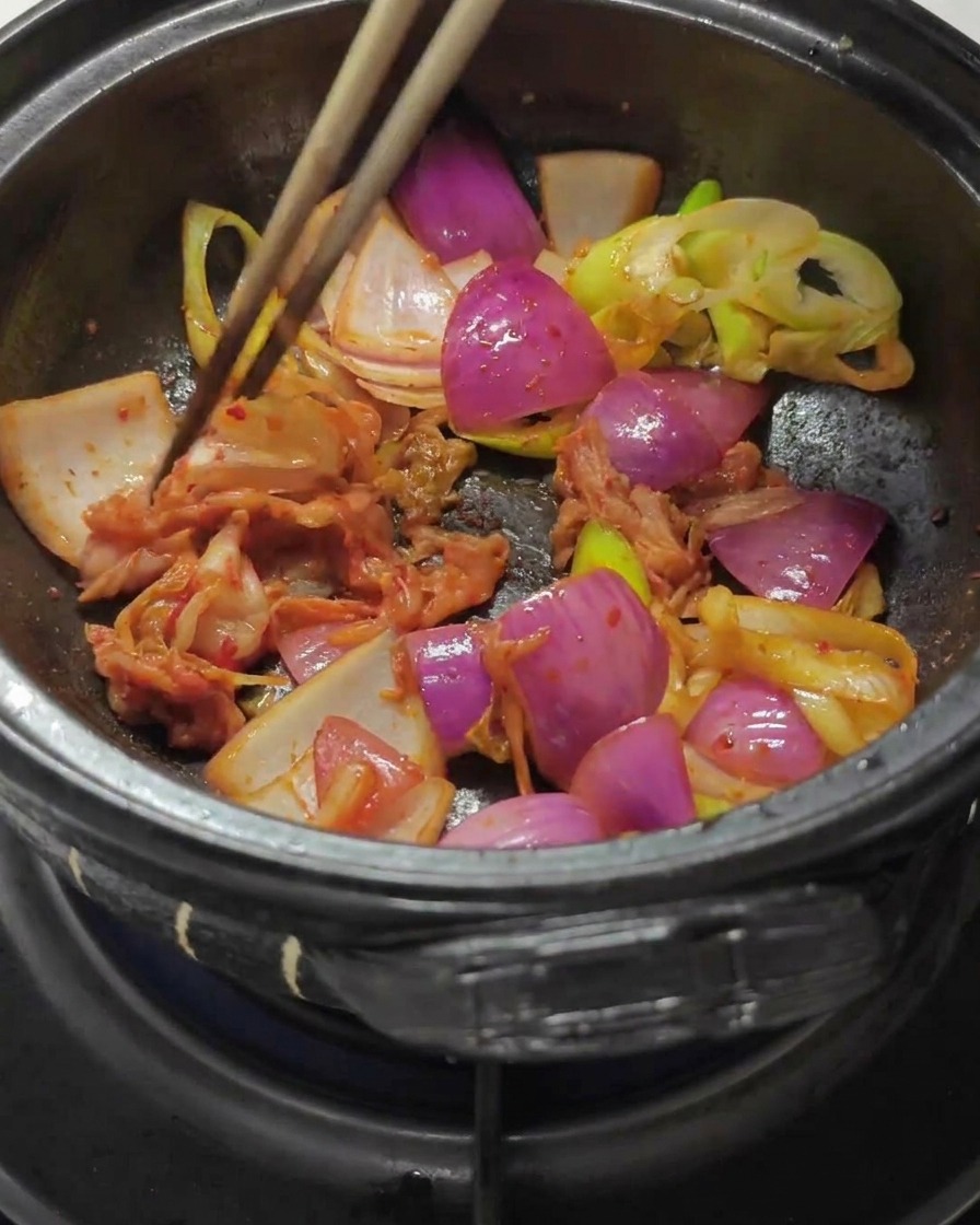 볶은 양파에 김치와 고추장을 넣고 섞는 모습