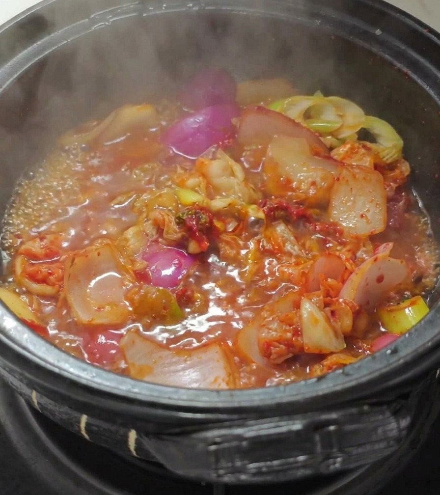 김치를 볶던 냄비에 끓는 물을 붓는 모습