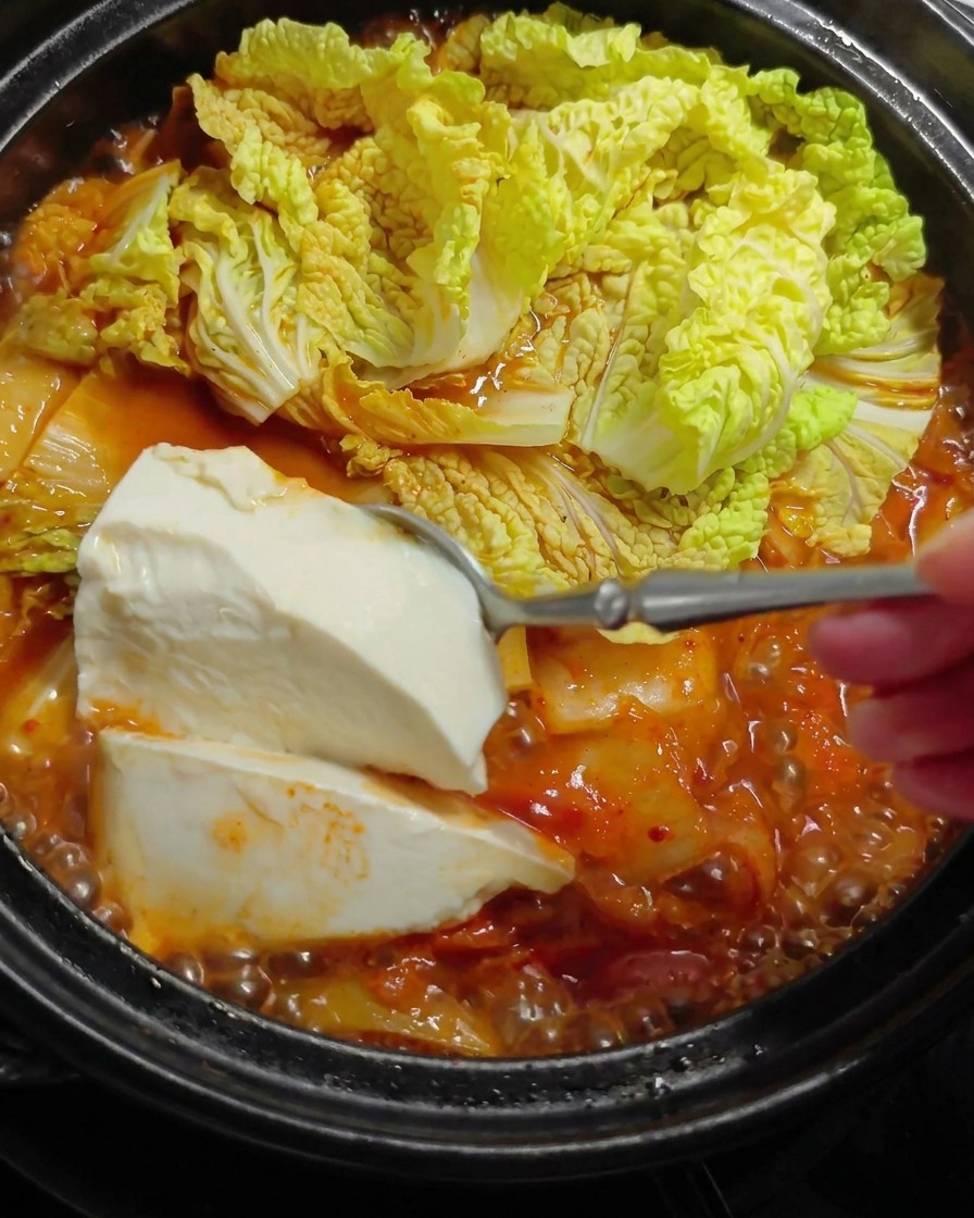 수저로 연두부를 떠서 국물에 넣는 모습