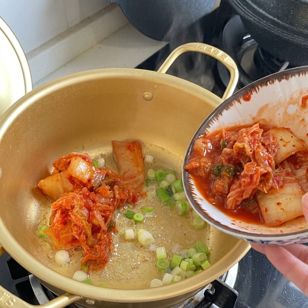 젓가락으로 신김치를 냄비에 옮겨 담는 장면