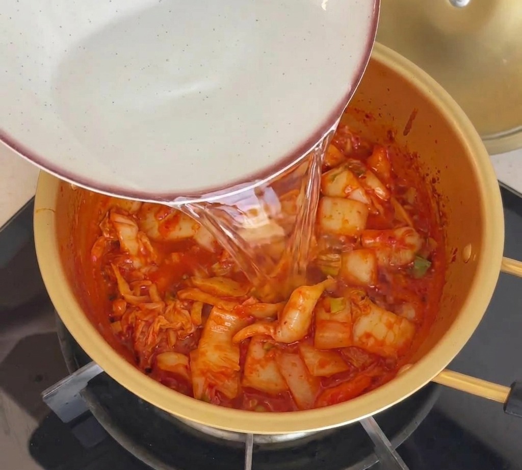냄비의 재료가 잠길 정도로 물을 붓는 모습