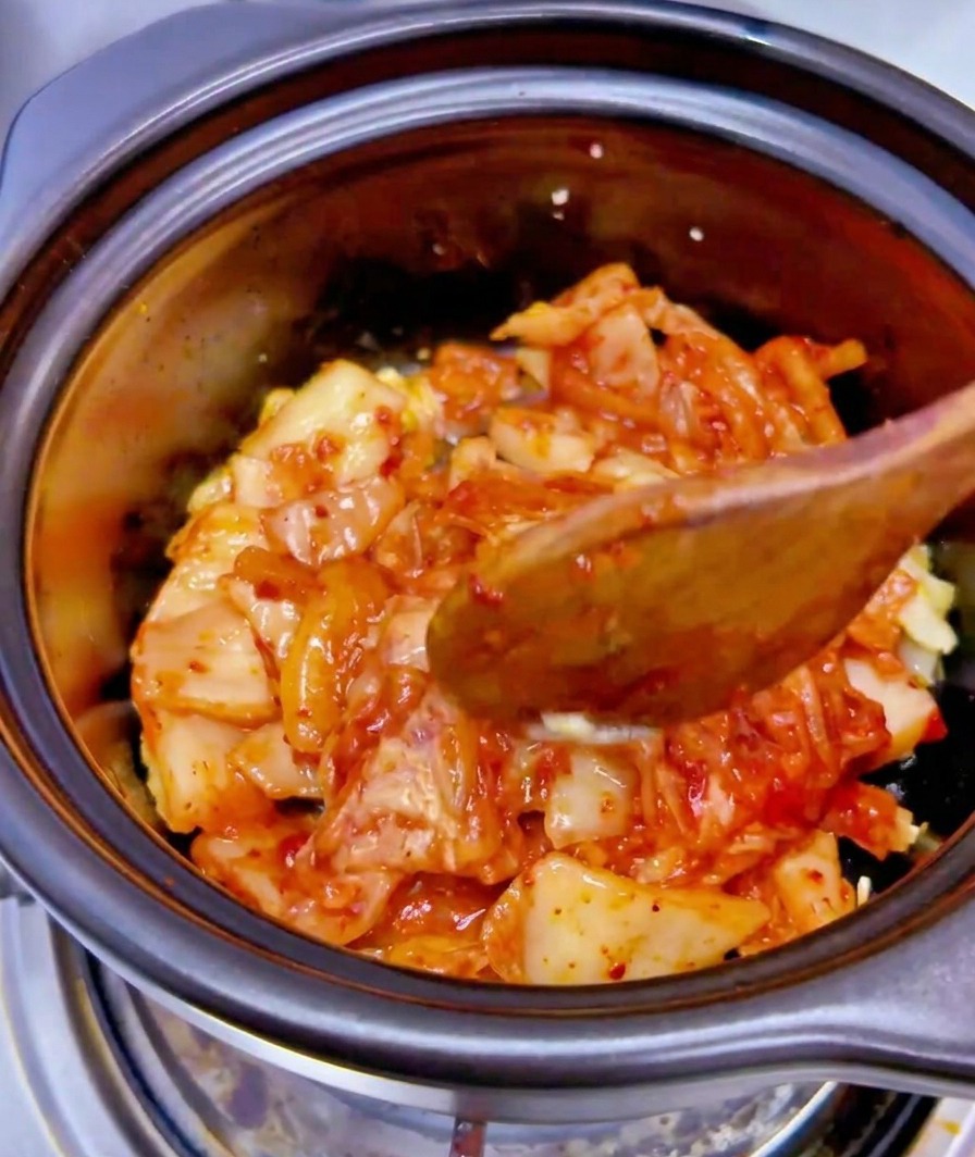 참치 캔에 들어있는 국물을 볶은 김치 위에 붓는 모습