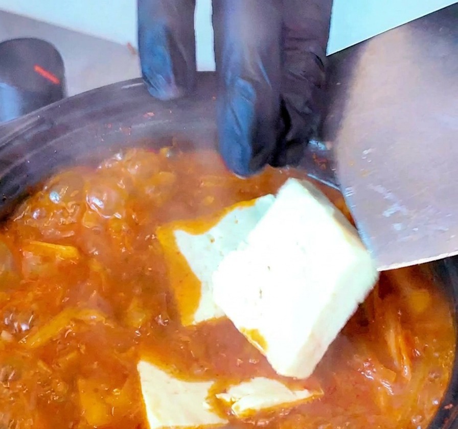 끓어오르는 찌개에 두부를 가지런히 넣는 모습