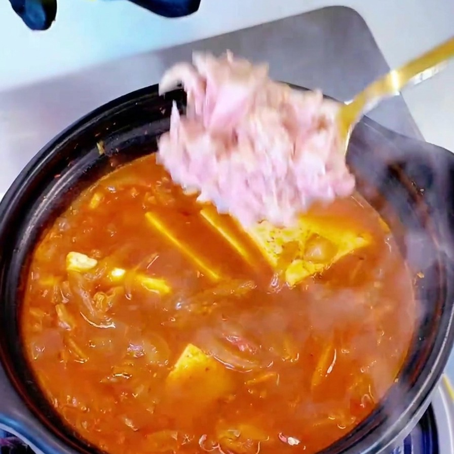 찌개 위에 참치 살코기를 듬뿍 얹는 모습