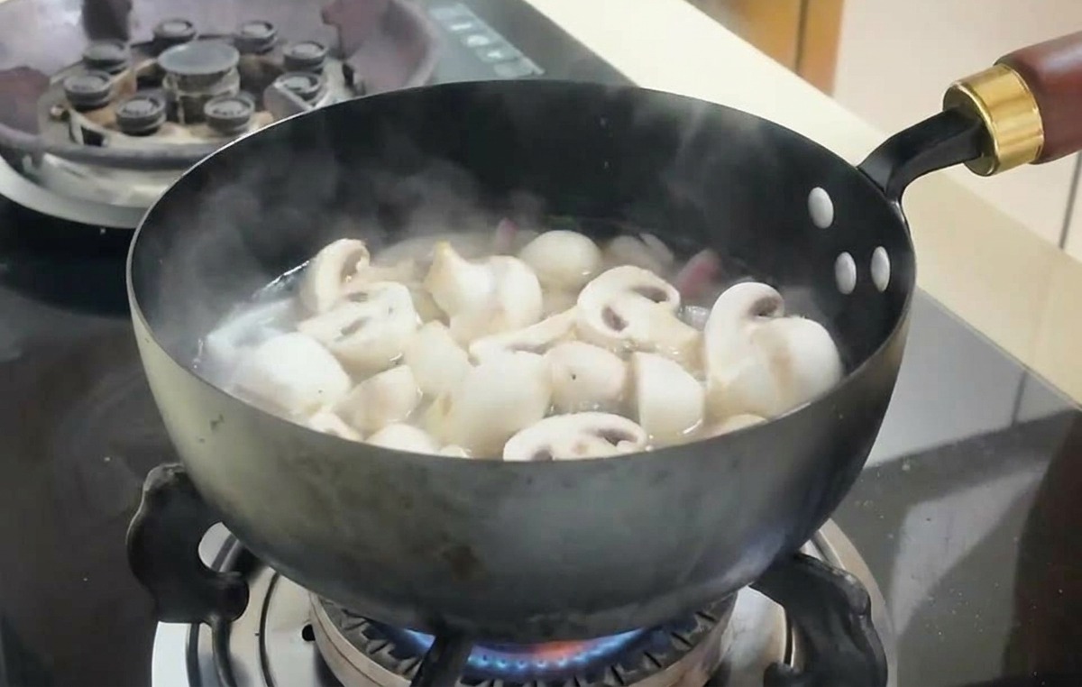 끓는 육수 안에 양송이버섯과 두부 큐브가 들어가 시머링되는 모습.