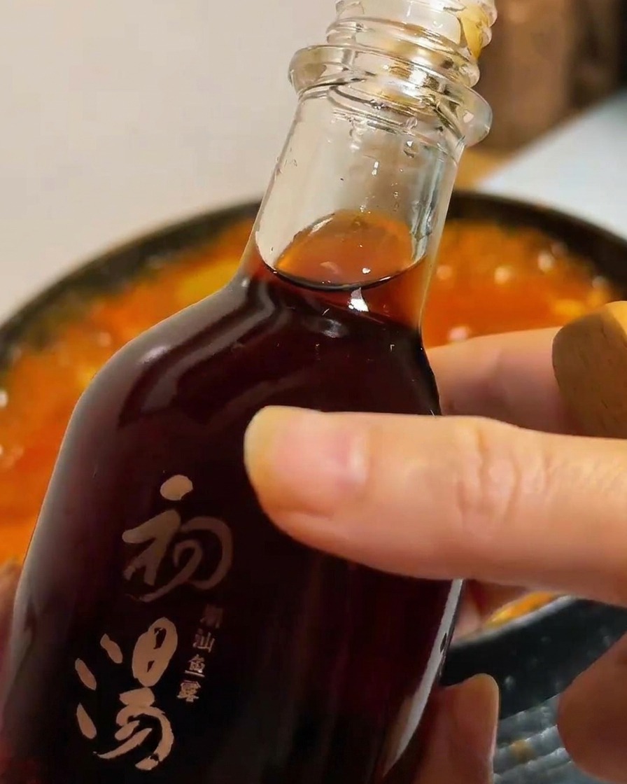 찌개에 액젓을 한 숟가락 넣는 모습.