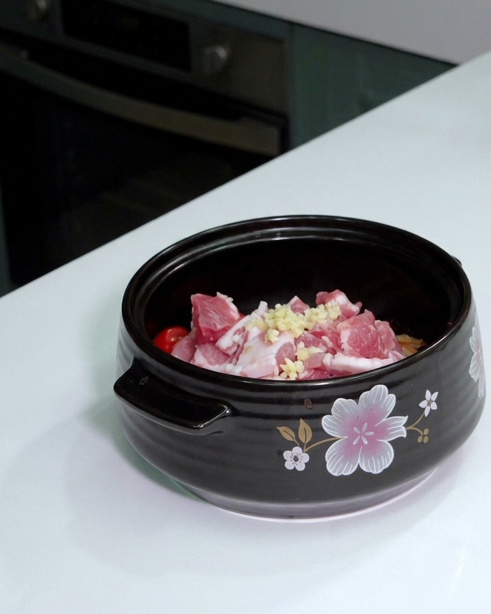 삼겹살 위에 다진 마늘 한 숟가락이 놓여 있는 모습.