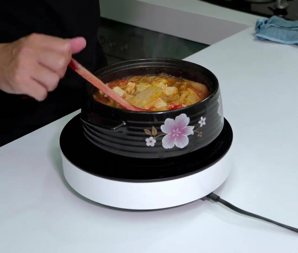 보글보글 끓는 김치찌개 위에 타바스코 소스를 두르는 모습.