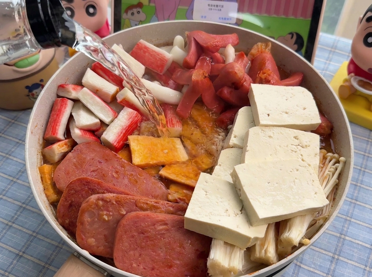 재료가 담긴 냄비 가장자리로 뜨거운 물을 조심스럽게 붓는 모습