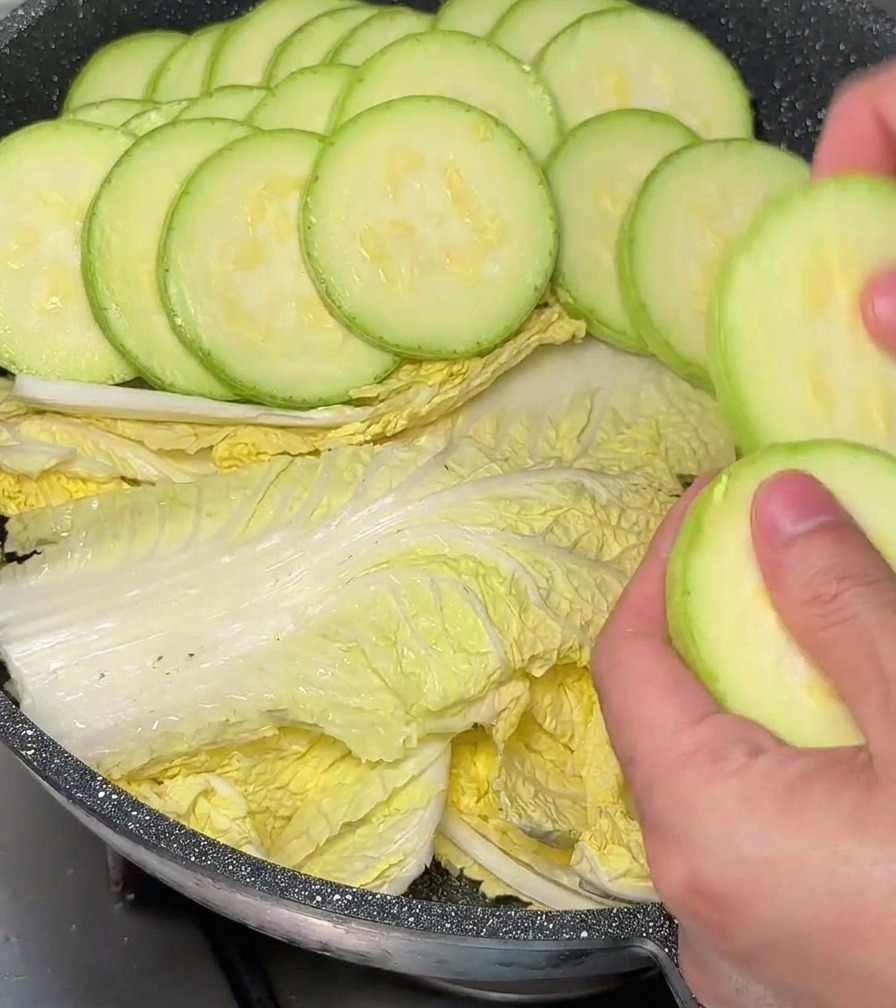 배추가 깔린 냄비 가장자리에 애호박을 겹겹이 두르고 있는 모습