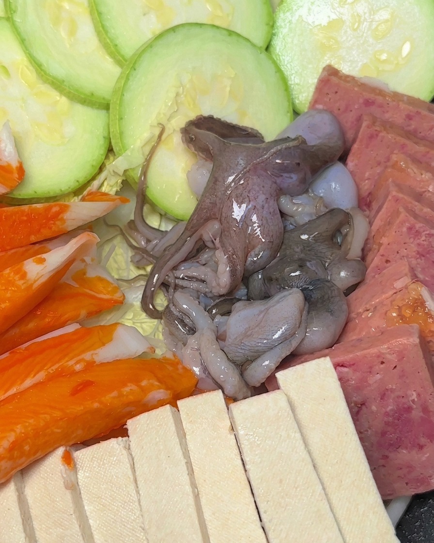 냄비 안에 애호박, 스팸, 두부, 맛살, 낙지가 예쁘게 세팅된 모습