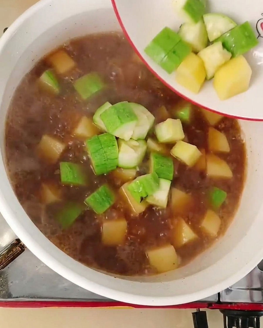 끓는 육수에 손질한 애호박과 양파를 넣는 장면