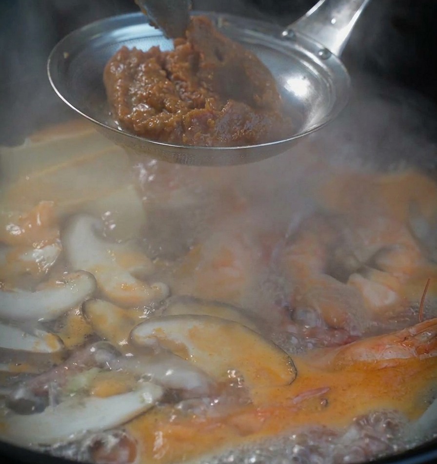 체망에 된장을 듬뿍 담아 끓는 찌개 위에서 풀 준비를 하는 모습.
