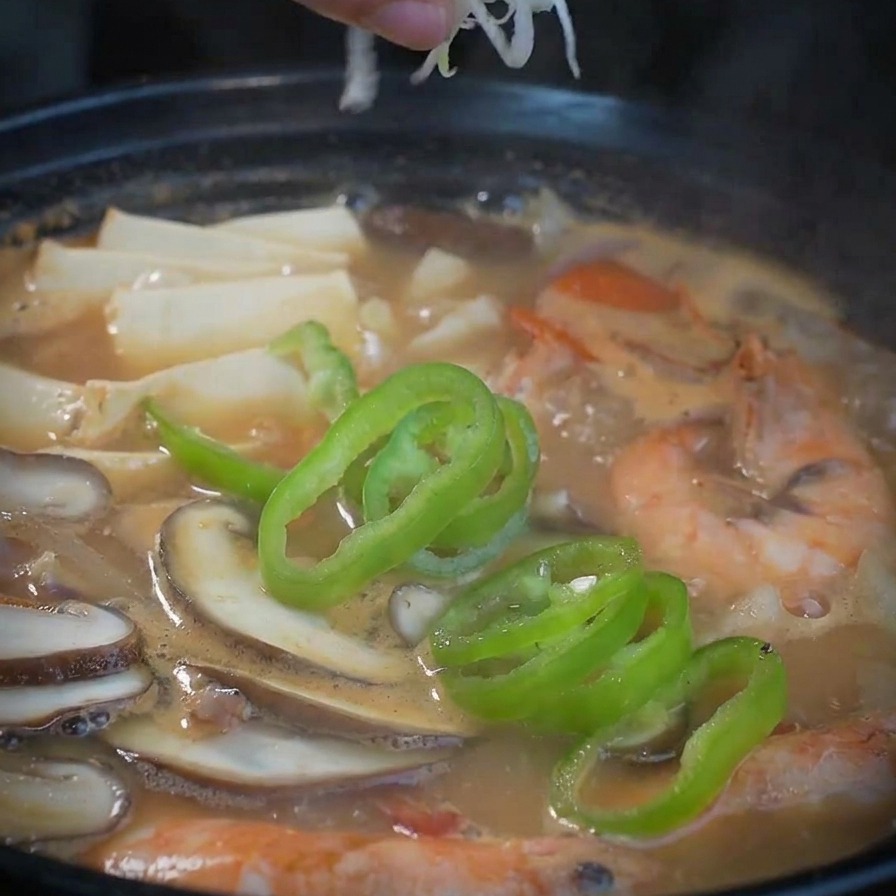 완성된 해물 된장찌개 위에 대파를 듬뿍 올리는 모습.