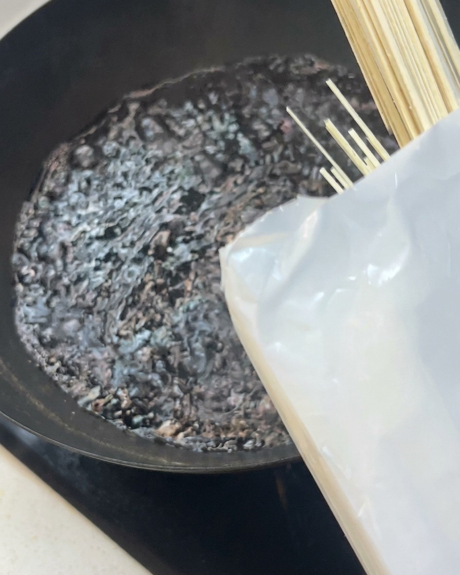 끓는 물이 담긴 웍에 마른 면을 넣는 모습