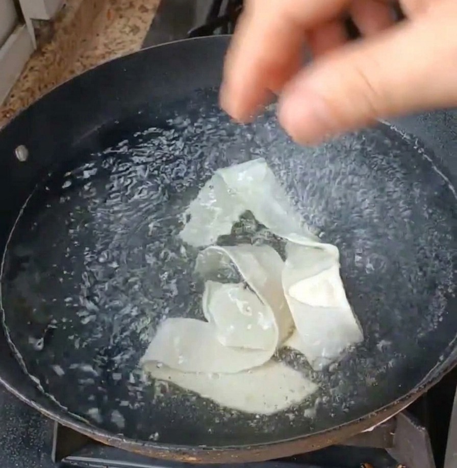 보글보글 끓는 물에 넓적한 면발과 초록색 잎채소를 넣고 삶는 모습.