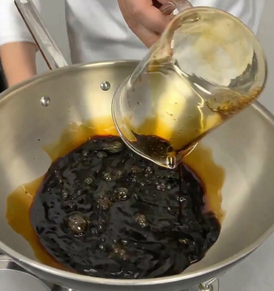 간장이 담긴 냄비에 투명한 맛술을 붓는 모습.