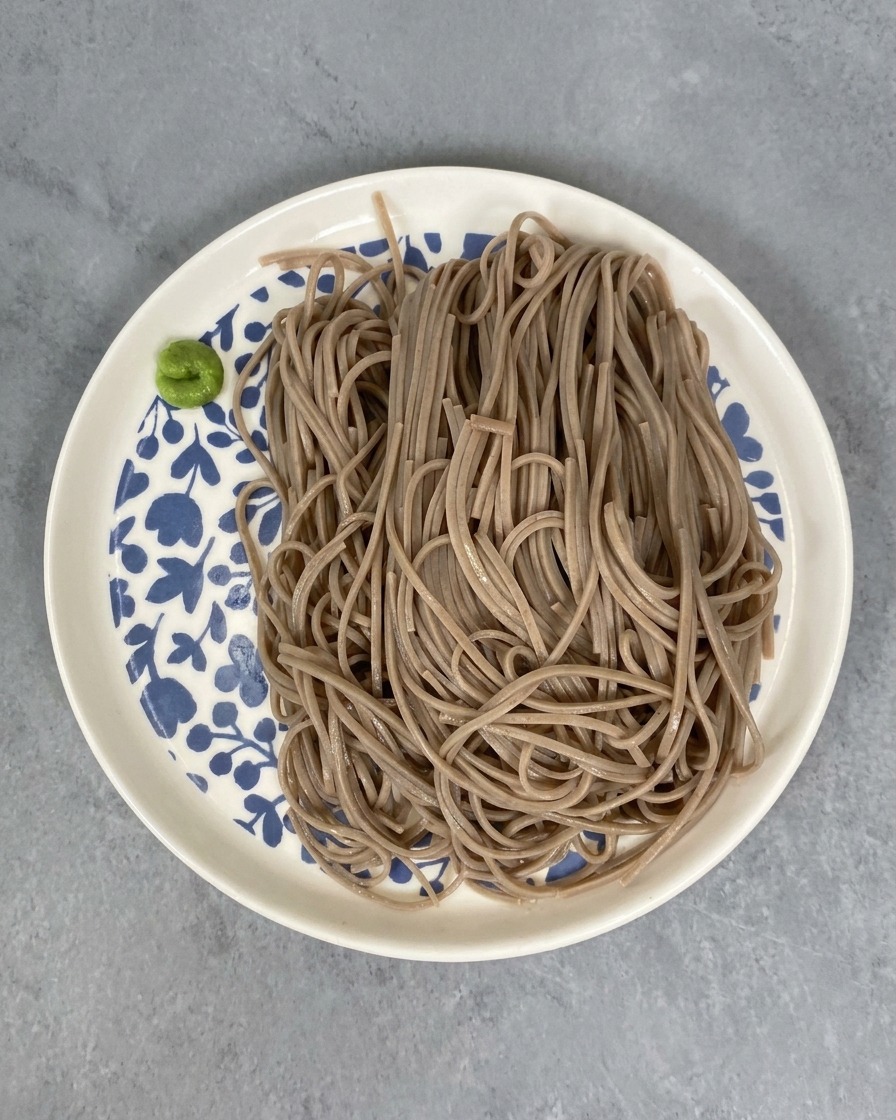 접시에 담긴 메밀면 옆에 놓인 초록색 와사비.