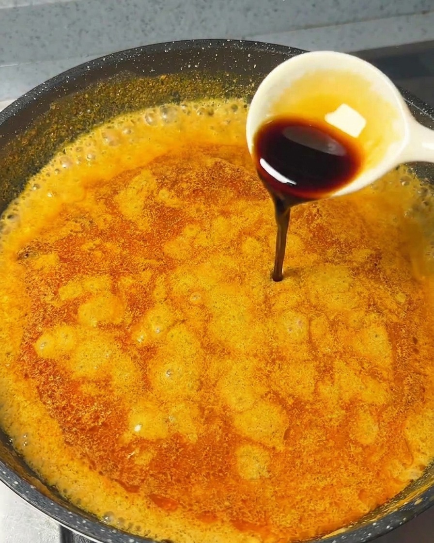 팬 안의 카레 소스에 진한 간장을 한 스푼 더하는 모습