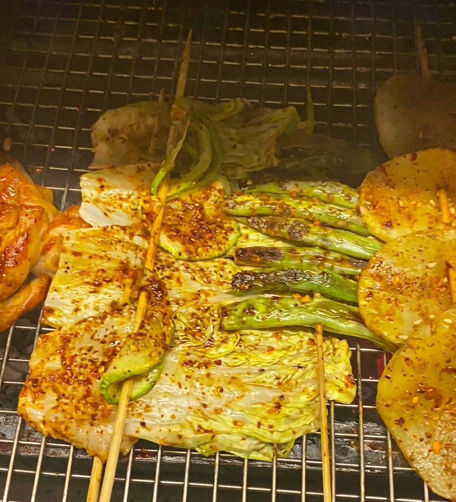 진한 BBQ 소스를 바르고 쪽파를 뿌린 구운 닭고기와 채소의 근접 촬영