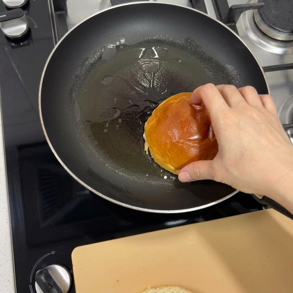 달궈진 프라이팬에 브리오슈 번을 올려 안쪽 면이 노릇노릇해질 때까지 굽는 모습.