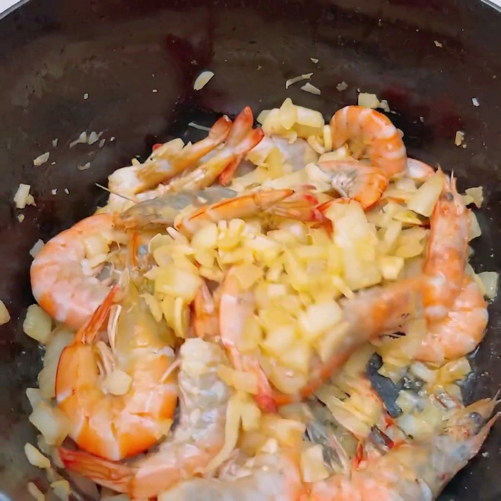 익어가는 새우가 든 냄비에 썬 토마토를 넣는 모습.