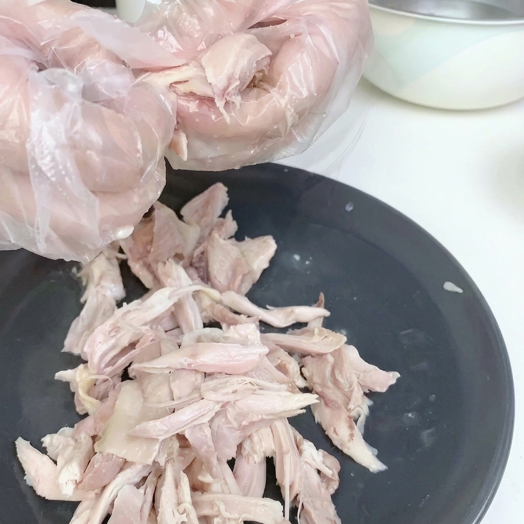 껍질을 제거한 삶은 닭고기 살을 접시에 담아 놓은 모습.