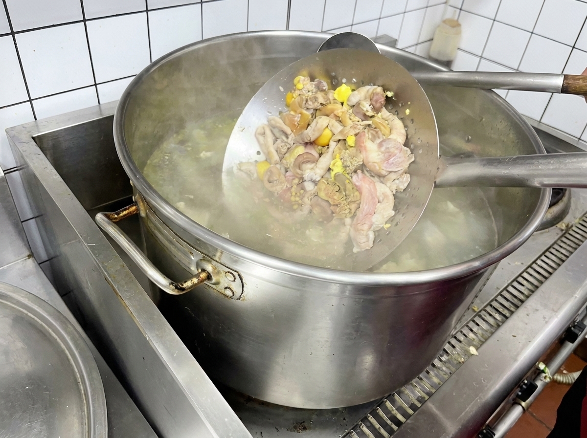 체에 닭 내장을 담아 끓는 물에 살짝 데치는 모습.