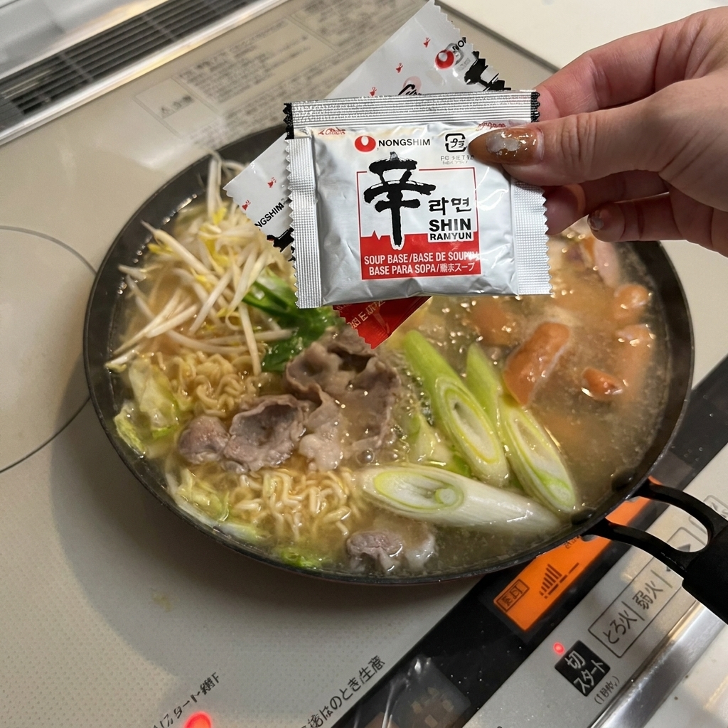 부대찌개 국물에 라면 스프를 넣는 모습.