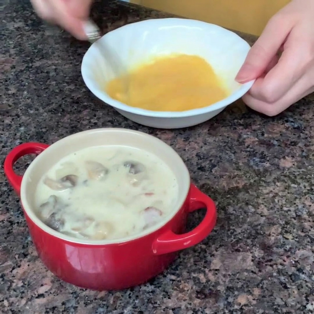 작은 그릇에서 달걀을 포크로 풀어주는 모습.