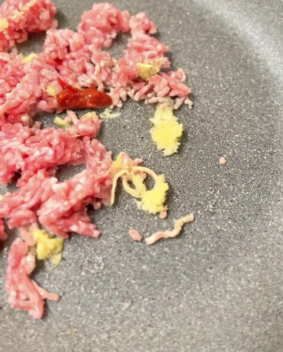 노릇하게 볶아진 돼지고기에 미소 된장을 넣고 섞는 모습.