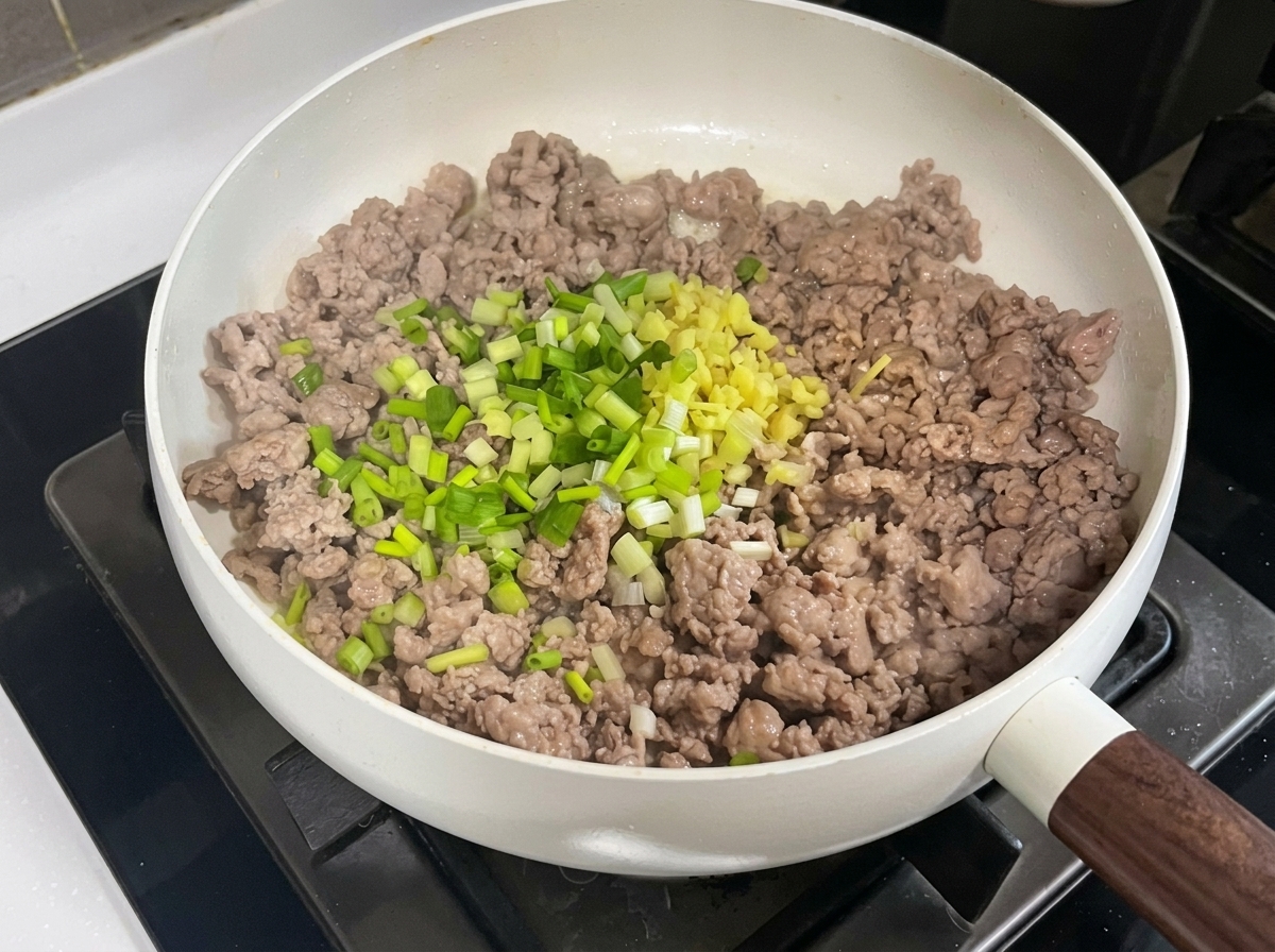 팬에 다진 향신 채소와 두반장, 된장을 넣고 섞는 모습.