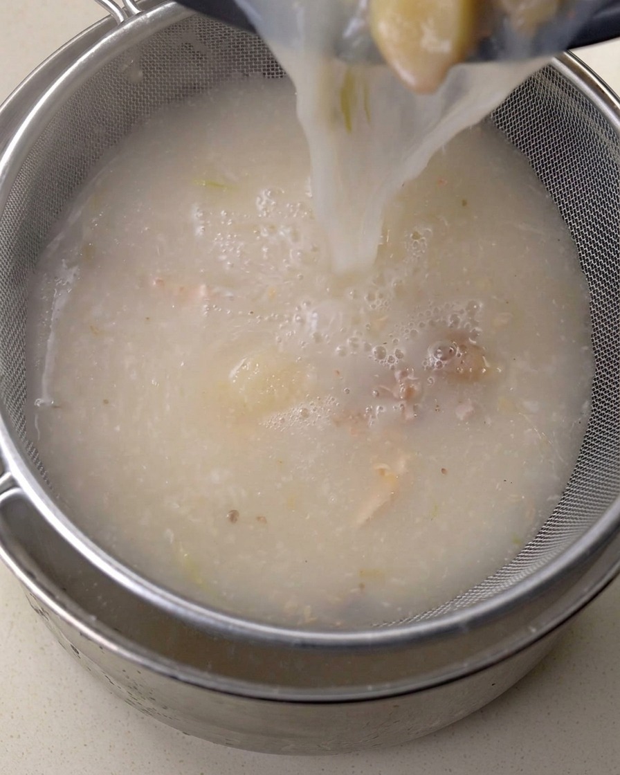 고운 금속 체에 육수를 걸러내는 모습.