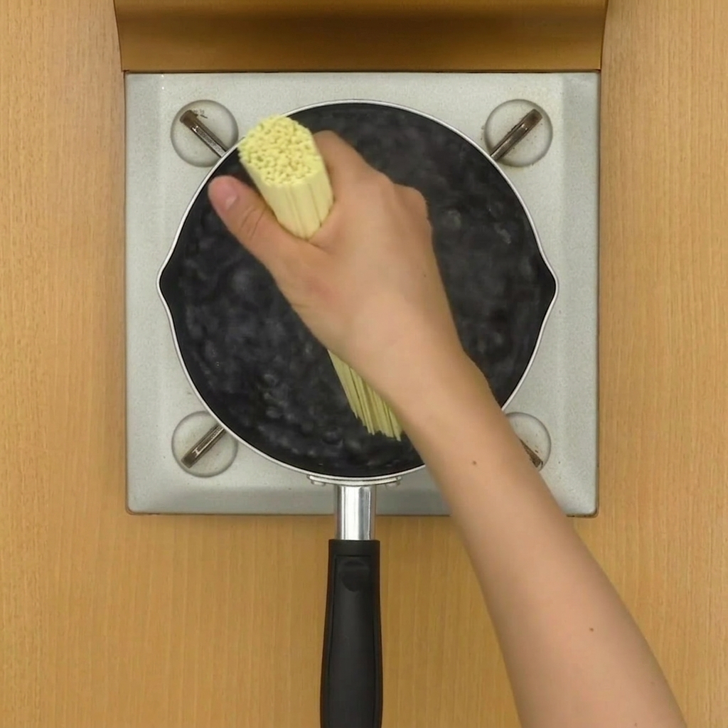 냄비에서 면을 삶으며 젓가락으로 젓는 모습.