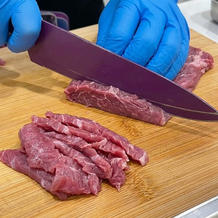 나무 도마 위에서 소고기 양지를 얇게 썰고 있는 모습.