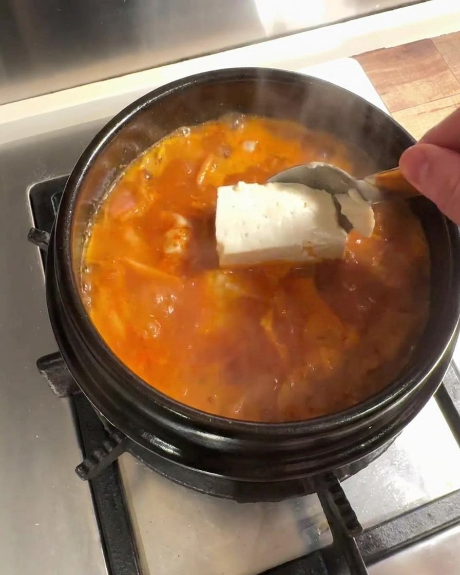 끓는 국물에 큼직하게 썬 두부를 넣는 모습.