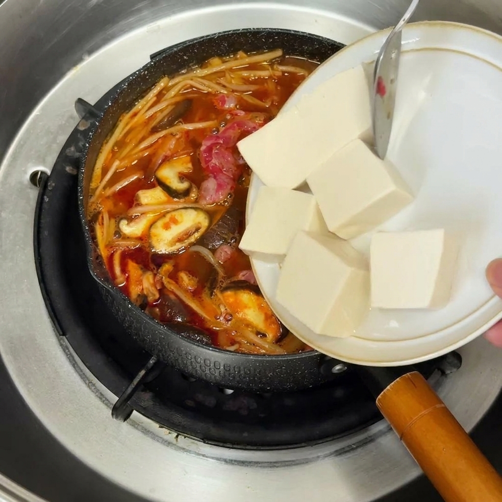 기름을 두른 노란색 팬에서 볶아지고 있는 다진 적양파입니다.