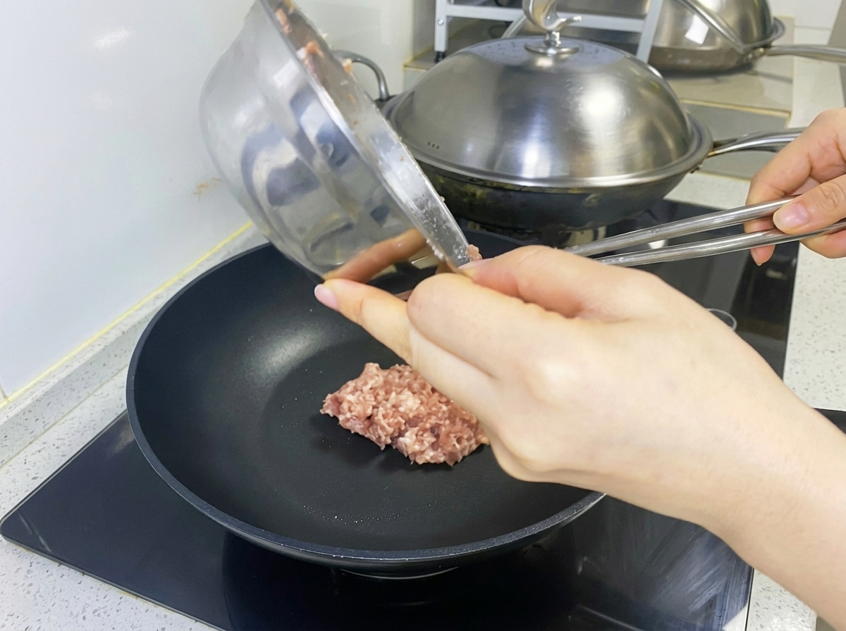 팬에 고기 반죽을 올려 패티 모양으로 만드는 모습.