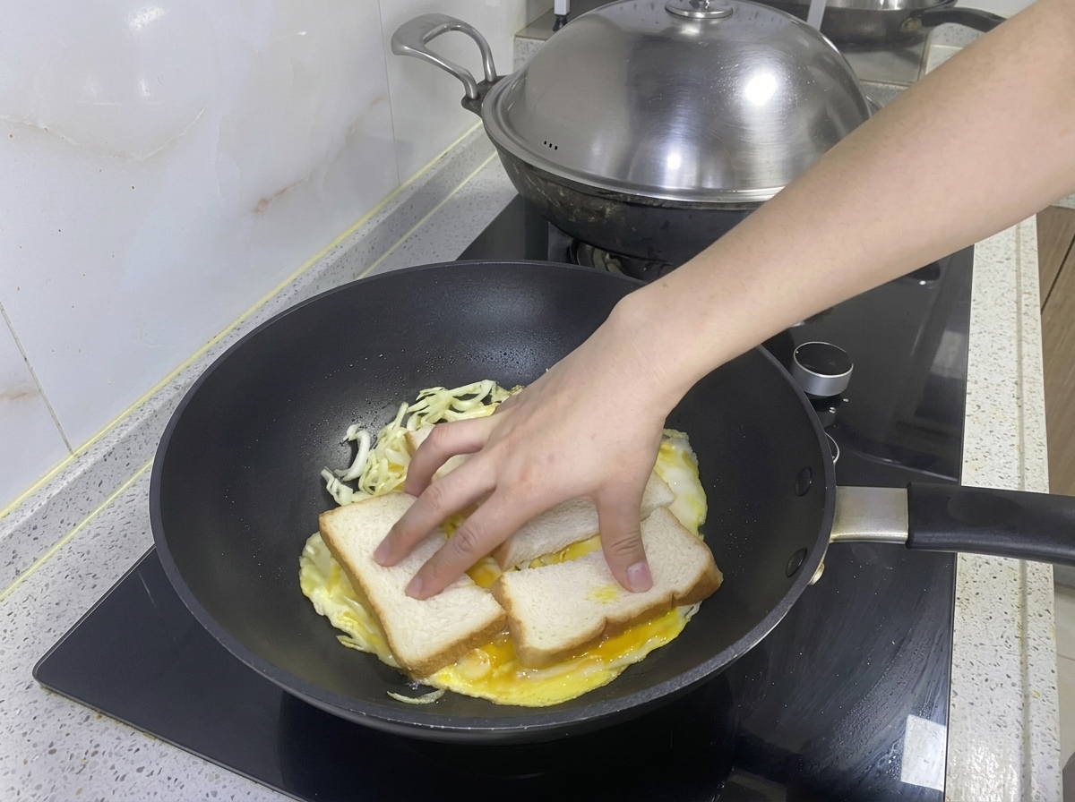 익어가는 계란 양배추 위에 식빵 두 장을 올리는 모습.