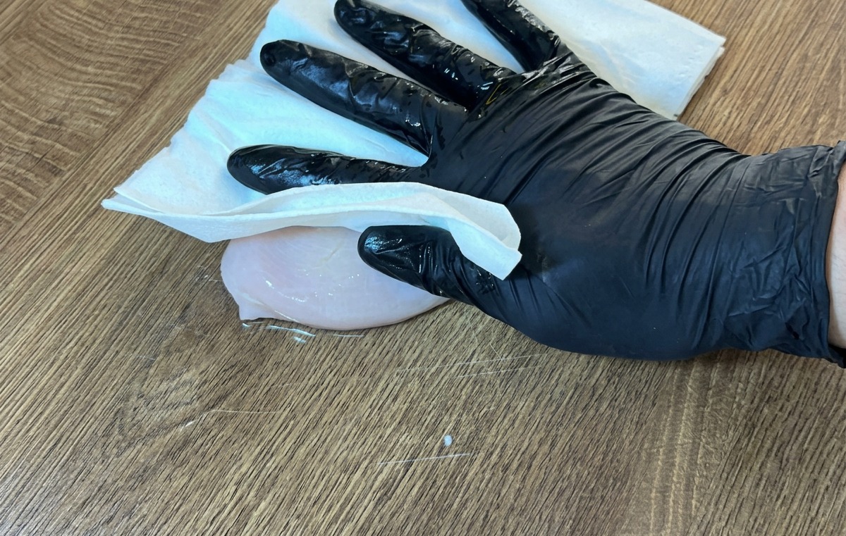 키친타월로 닭가슴살의 물기를 닦아내는 모습.