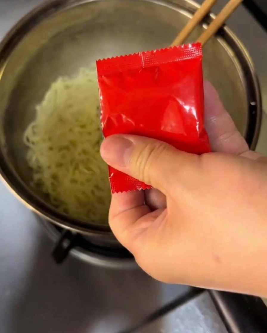끓는 면에 양념과 매운 소스를 섞는 모습.